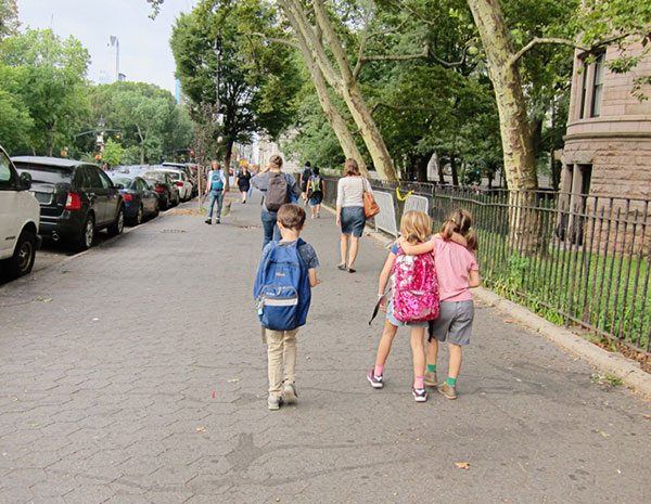 boy reading while walking to school