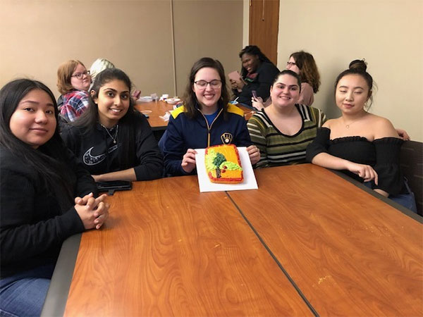 Students displaying cake