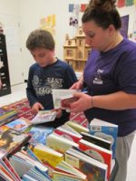 mother selecting books with her son