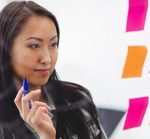young woman writing and organizing her story with sticky notes